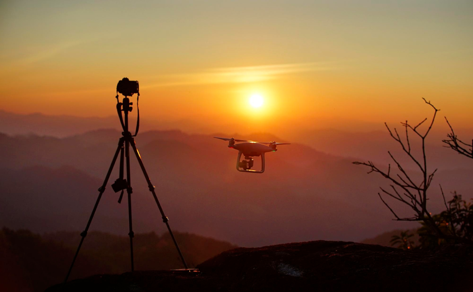 Camera and aircraft silhouette against a sunset sky